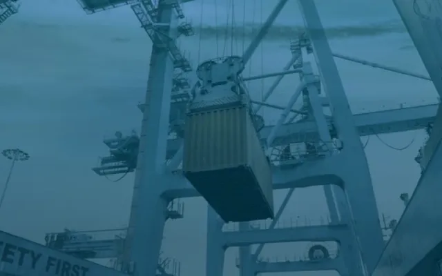 Grúa portuaria levantando un contenedor para exportación desde Cúcuta, Colombia, con tono azul petróleo